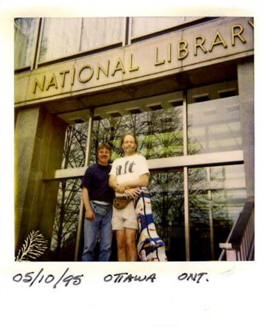 Jim Fish and Valdy on tour two men, Jim and Valdy, stand in front of the National Library; taken on May 10th, 1985
