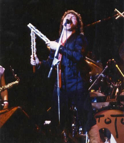 Bobby Kimbal singing passionately and playing two jesticks